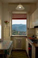 A cozy kitchen with a stunning mountain view through the window, capturing warmth and tranquility.